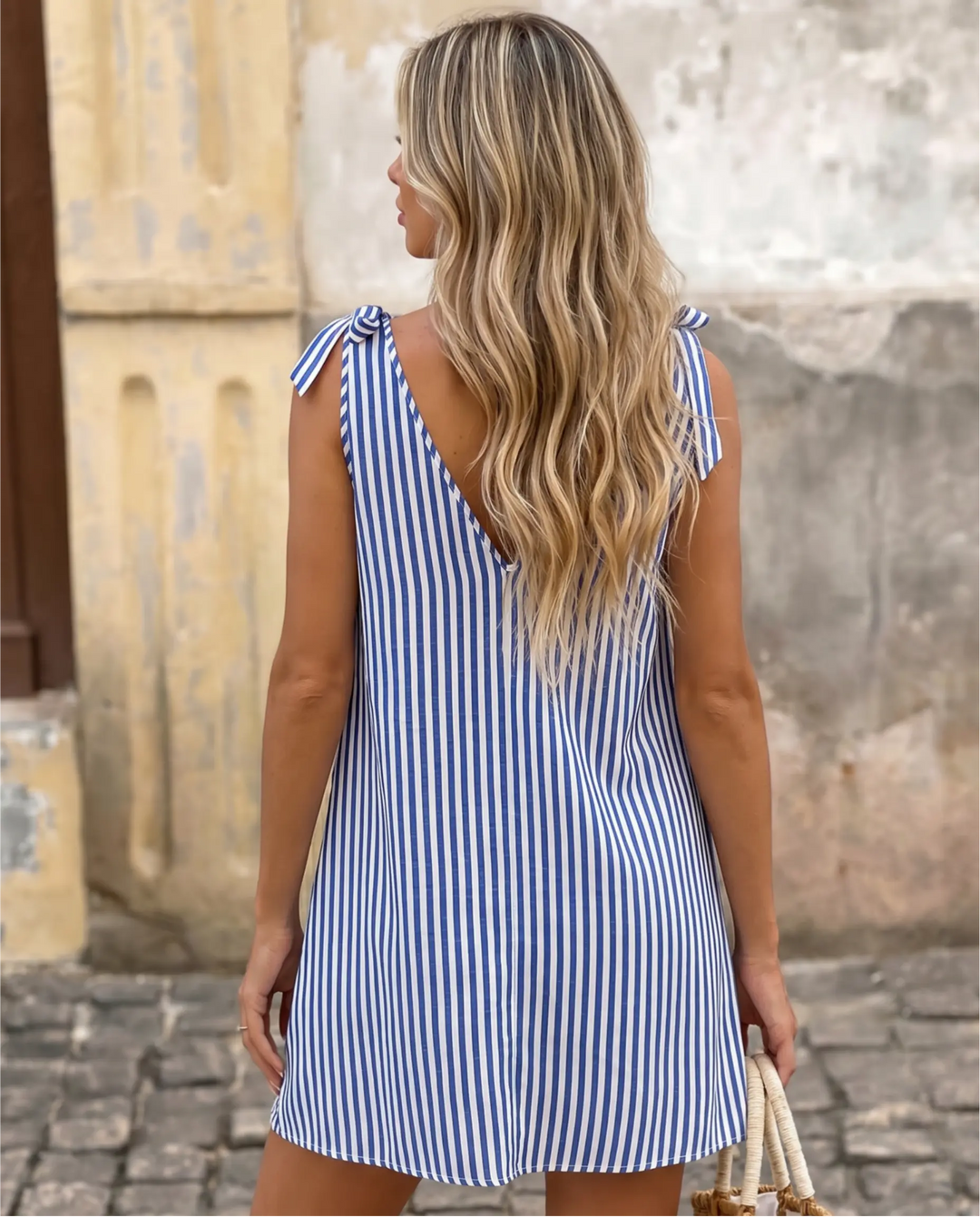 Abito mini a righe verticali blu e bianco con scollo a V annodato